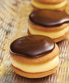 three chocolate covered cookies sitting on top of a glass table