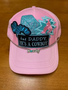 Pink trucker hat with adjustable snap back But Daddy He's a Coyboy patch with squash blossom, diamond, and bronc rider patches Silver and turquoise Howdy hat chain Trucker Snapback Baseball Cap For Rodeo, Trucker Style Snapback Baseball Cap For Country Events, Western Style Snapback Baseball Cap For Country Events, Western Style Trucker Hat For Country Events, Western Trucker Hat With Flat Bill For Country Events, Western Flat Bill Trucker Hat For Country Events, Western Style Adjustable Trucker Hat 5-panel, Adjustable Western 5-panel Trucker Hat, Adjustable Western Style Trucker Hat