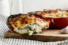 two stuffed peppers sitting on top of a cutting board