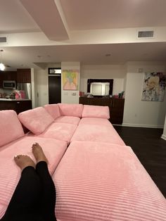 a person laying on top of a pink couch in a living room