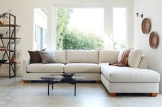 a living room filled with furniture and a large white couch in front of a window