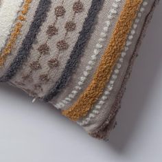 a close up of a striped pillow on a white surface with an orange and gray stripe