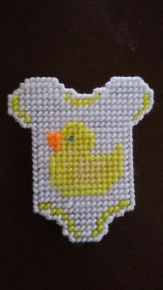 a close up of a small cross stitch ducky on a black shirt with white and yellow trim