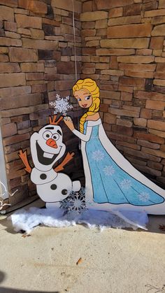 a cardboard frozen princess and snowman standing in front of a brick wall with the word disney written on it