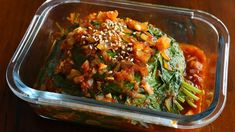 a plastic container filled with food on top of a wooden table