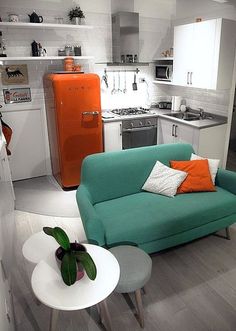 a living room filled with furniture next to an orange refrigerator and stove top freezer