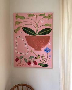 a painting hanging on the wall next to a wooden chair and table with a plant in it