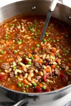 a pot filled with pasta and meat soup