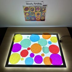 a table that has a lit up tray on top of it with different colored dots