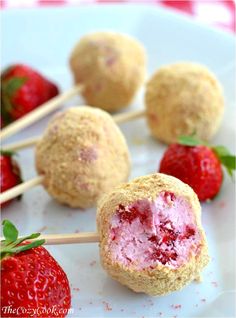 some strawberries are being dipped with ice cream and sitting on toothpick sticks