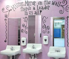 a bathroom with pink walls and white sinks