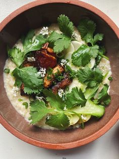 a bowl filled with rice, meat and cilantro