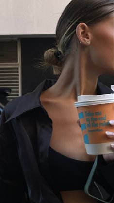 a woman holding a coffee cup in her right hand