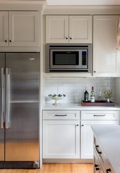 a kitchen with stainless steel appliances and white cabinets