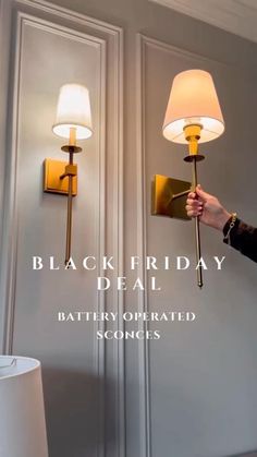 a person holding a lamp in front of a wall mounted light with the words, black friday deal battery operated sconces