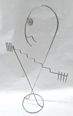 a metal sculpture that has been placed in the shape of a face and four bars on it