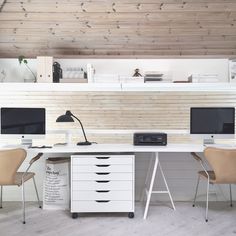 an office with two computer desks and chairs