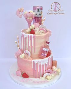 a three tiered cake with pink icing and candies