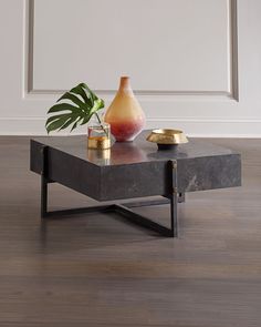 a coffee table with a vase and two candles on it