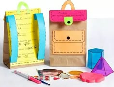 two paper bags and some craft supplies on a table