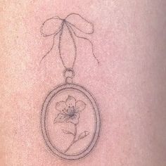 a small tattoo on the back of a woman's stomach with a flower in it