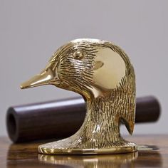 a golden duck figurine sitting on top of a wooden table next to a judge's gaven