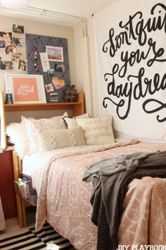 a bed room with a neatly made bed and a wall hanging on the wall above it