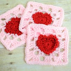 two crocheted coasters with red hearts on them