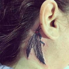 a woman with a tattoo on her neck and behind the ear is a black feather