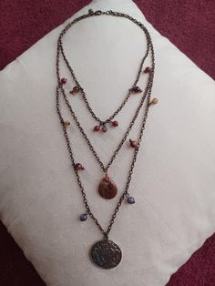 This 3-layered necklace was hand-assembled using bead charms and a half-dollar-sized pendant with a Geisha on it from old jewelry, plus a tumbled stone (rainbow jasper?) into which I've drilled a hole so it can be hung as a pendant. The result is a boho-style piece with earthy tones like my current home in the north-central Arizona landscape. The Geisha pendant is very unusual; the design is on both sides. It all comes together with a dark copper chain with lobster clasp. Dark Copper Red, Arizona Landscape, Boho Layering, Dark Copper, Red Beads, Copper Red, Old Jewelry, Copper Chain, Red Bead