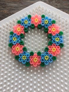 a colorful beaded wreath sitting on top of a white plate