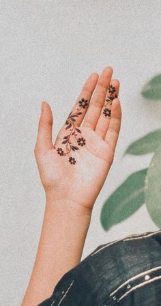 a woman's hand with small flowers on it