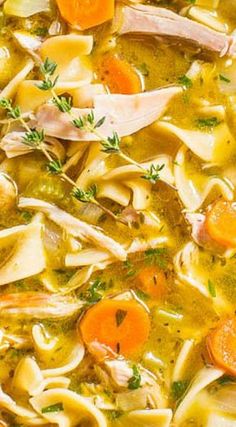 a bowl filled with pasta, carrots and meat soup on top of a table