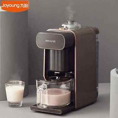 an espresso machine sitting on top of a counter next to a glass of milk