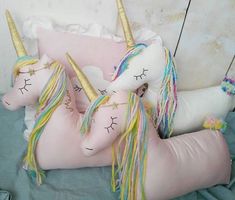 two stuffed unicorns laying on top of each other