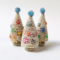 three small christmas trees made out of candy and sprinkles on white background