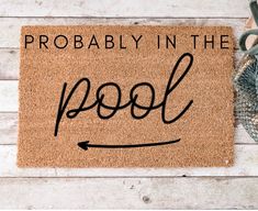 a door mat with the words probably in the pool on it next to some scissors