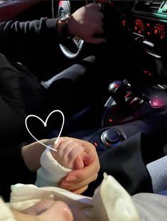 a baby in a car with a white heart on it's head and hands