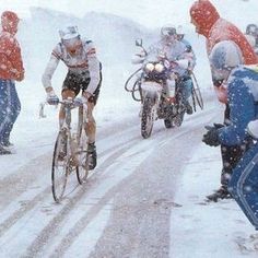 a group of people riding bikes down a snow covered road