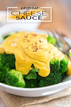 a white bowl filled with broccoli covered in cheese sauce on top of a table