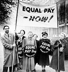 a group of people holding protest signs in front of a building with the words equal pay now written on them