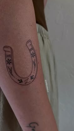 a tattoo on the arm of a man with a horseshoe