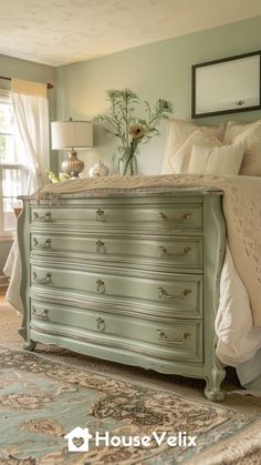 a bed room with a neatly made bed and a large dresser in it's center