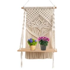 a macrame wall hanging with two potted plants