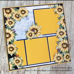 a card with sunflowers on it sitting on top of a wooden table next to a piece of paper