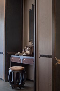 a dressing table with stool and mirror in a room that has wooden paneling on the walls