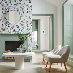 a living room with two chairs and a table in front of a mirror on the wall