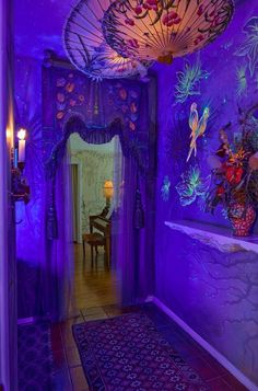 a room with purple walls and decorations on the ceiling, along with a piano in the hallway