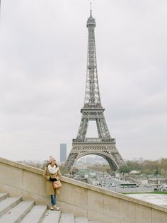 a woman standing in front of the eiffel tower