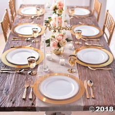 the table is set with gold and white plates